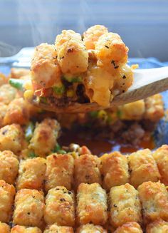 a spoon full of tater tots with broccoli and cheese