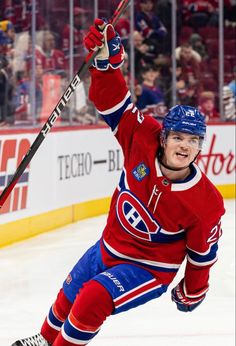 a hockey player is holding his arms up in the air while he skates on the ice