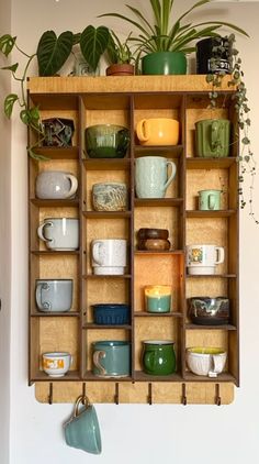 a wooden shelf filled with lots of different types of cups and saucers on top of it