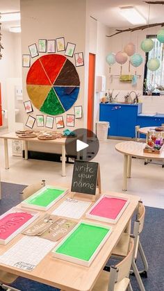 a classroom with tables, chairs and pictures on the wall