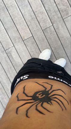 a person with a spider tattoo on their leg