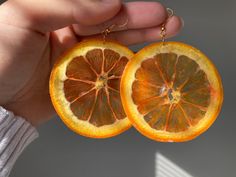 two halves of an orange being held by a person