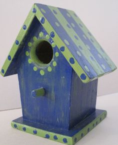 a blue birdhouse with polka dots painted on it