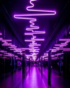 a long hallway with purple lights on the ceiling