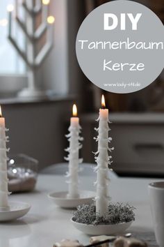 some white candles sitting on top of a table