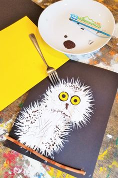 an owl is drawn on a piece of paper next to a plate with a fork