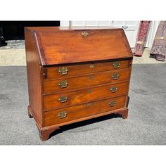 an old wooden chest of drawers sitting on the ground