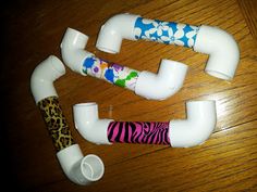 three different types of plastic pipes on a wooden table with flowers and leopard print designs