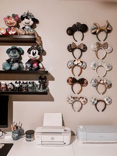 there are many mickey mouse ears on the wall above the printer and other items in front of it