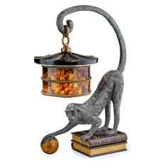 a lamp that is on top of a book with a cat figurine next to it