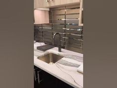 a kitchen with marble counter tops and stainless steel sink faucets in the center