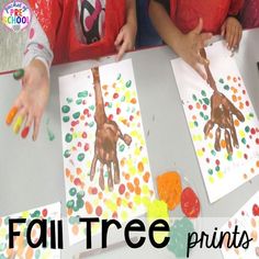 two children sitting at a table making handprints on paper with the words fall tree prints