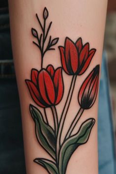 a close up of a person's arm with tattoos on it and red flowers