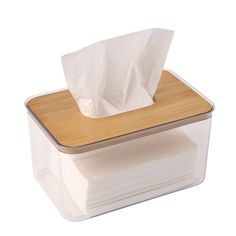 a stack of tissues sitting on top of a plastic container next to a wooden lid