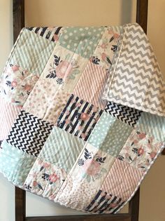 a baby quilt hanging on the back of a chair