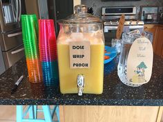 a kitchen counter topped with lots of different colored cups and containers on top of it