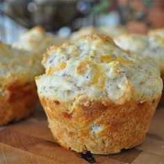 several muffins are sitting on a wooden cutting board