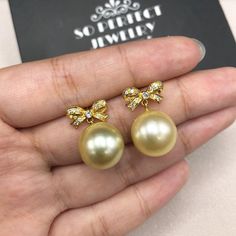 We are presenting you A PERFECT PAIR OF CREAMY WHITE SOUTH SEA PEARLS! WITH EXCELLENT LUSTER. Accented with 22 pieces or superb quality, F/VS sparkling diamonds. SET IN HANDCRAFTED, 18K SOLID YELLOW GOLD SCREWED BACK EARRINGS. DANGLING BOW DESIGN, ELEGANT AND CUTE! IN CASE OF RETURN FOR US BUYERS. BUYERS MAY SEND THE ITEMS BACK TO OUR US-BASED OFFICE IN SALT LAKE CITY, UTAH ONLY ONE ITEM AVAILABLE!! NO DUPLICATES!! WHAT YOU SEE IN THE PICTURES IS WHAT YOU WILL GET SOLIDLY HANDCRAFTED EARRINGS! S Exquisite Gold Round Pearl Earrings, Luxury Round Pearl Earrings For Wedding, Pearl Bridal Earrings In Yellow Gold As Gift, Yellow Gold Pearl Bridal Earrings Gift, Luxury Gold Round Bridal Earrings, Exquisite Gold Pearl Earrings For Anniversary, Elegant Yellow Bridal Earrings For Wedding, Luxury Pearl Bridal Earrings Gift, High Luster Yellow Jewelry For Weddings