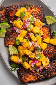 grilled fish with mango salsa and lime wedges