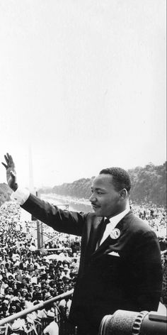 a man in a suit and tie giving a speech to a large group of people