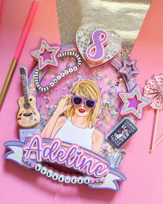 a pink table topped with an assortment of items and a sticker that says,'8 adelinne '