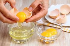 someone is squeezing an egg into a small glass bowl on a table with eggs in it