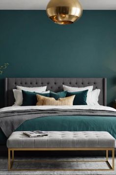 Luxurious bedroom with a teal accent wall, tufted gray bed, layered pillows, and a gold pendant light. Teal Room Aesthetic, Teal Bedroom Color Schemes, Dark Teal Bedroom Ideas, Teal Bedroom Walls, Dark Teal Bedroom, Teal Room, Teal Bedroom Ideas, Ensuite Bathroom Designs, Teal Accent Walls