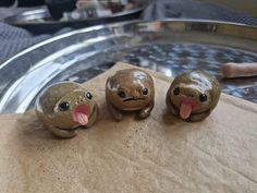 three little turtle figurines sitting on top of a piece of brown wax paper