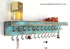 a wooden shelf with hooks and earrings hanging from it's sides on a wall