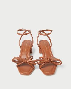 Mid-heel sandal with knotted bow detail in timber brown nappa leather. Features a padded leather footbed with gold stamped logo and an open, squared toe. 2-inch heel. Fall Palette, Spring Palette, Mid Heel Sandals, Clover Green, 2 Inch Heels, Heel Sandal, Letter Charms, Summer Ready, Sky High