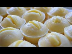 some dumplings are sitting on a plate and ready to be eaten with cheese sauce