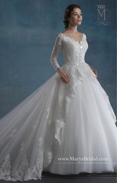 a woman in a wedding dress posing for the camera with her hands on her hips