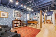 a living room filled with furniture and a book shelf on top of a hard wood floor