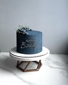 a blue birthday cake sitting on top of a white plate