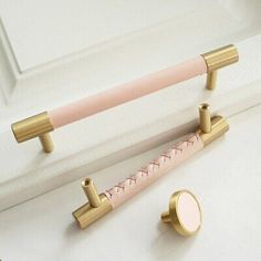 two pink and gold handles on a white door