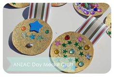 several medals with stars and jewels on them are shown in front of the words anzac day medal craft