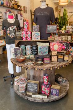 a display in a store filled with lots of greeting cards and other items on top of a wooden stand