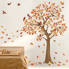 a bedroom with a tree and birds painted on the wall