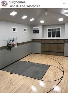 an indoor basketball court in the middle of a room with hardwood floors and white walls