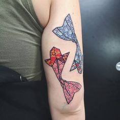 a woman with a tattoo on her arm has an origami fish design on it