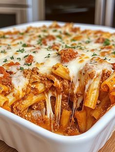 a casserole dish filled with pasta and meat covered in sauce, cheese and parmesan