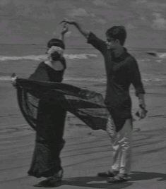 black and white photograph of two people on the beach