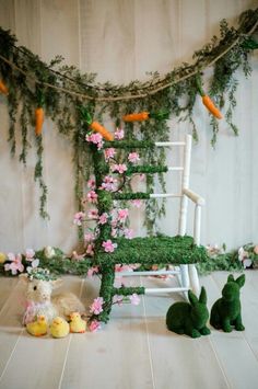 a chair made out of moss with flowers and bunnies on the floor next to it