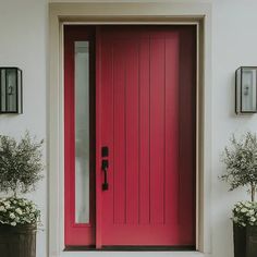 a red front door with two planters next to it