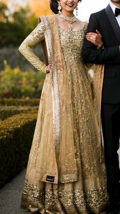 a man and woman standing next to each other in formal wear, posing for the camera