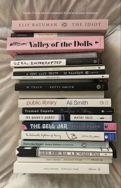 a stack of books sitting on top of a bed