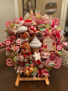 a christmas wreath with gingerbreads, candy canes and other holiday decorations on a table