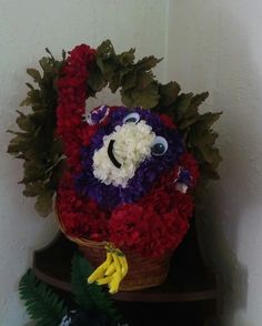 a basket filled with red, white and purple flowers sitting on top of a table