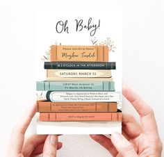 a person holding up a stack of books with the words oh baby on it in front of them