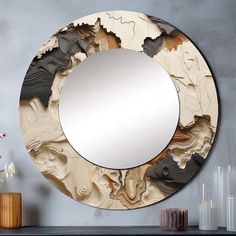 a round mirror sitting on top of a wooden table next to vases and flowers